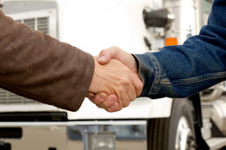 Image of customer and trucker shaking hands