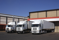 Image of three long haul trucks at the loading docks